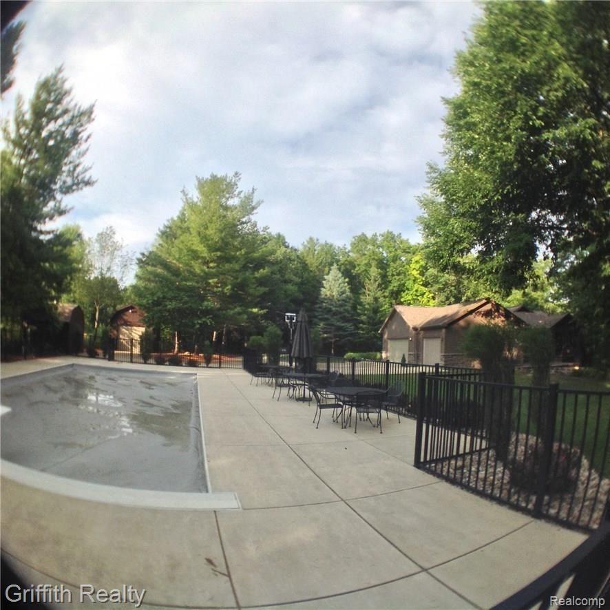Fish eye view of covered pool, outbuildings and home.