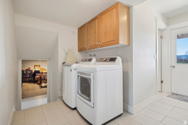 550 Pine Canyon Road Midway, UT 84049 - Photo 31 of 44 Dedicated laundry area featuring a washer and dryer set, wood-finish cabinetry, and light-toned tile flooring