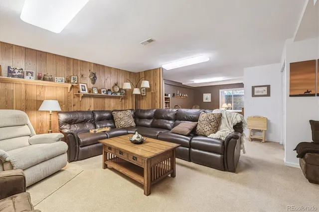 a living room with furniture and a view of kitchen