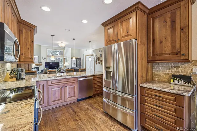 a kitchen with stainless steel appliances granite countertop a refrigerator sink and cabinets