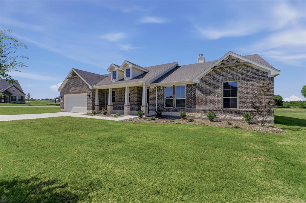 130 Fossil Canyon Drive Rhome, TX 76078 - Photo 4 of 25 Brick and stone facade residence featuring a covered front porch with columns