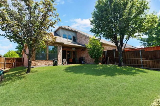 a view of a house with a yard and tree
