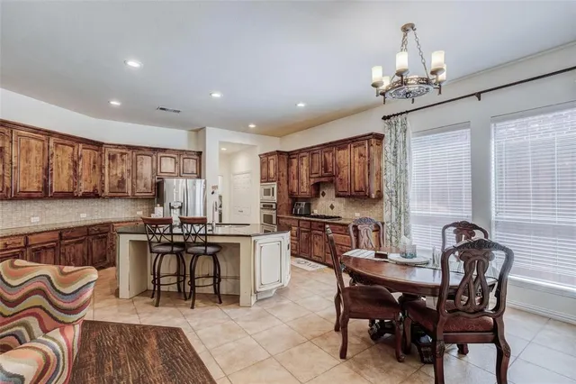 a view of a dining room with furniture a kitchen and chandelier