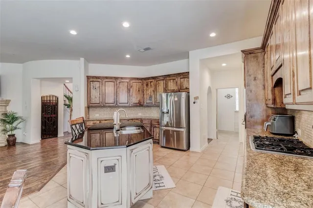 a kitchen with stainless steel appliances granite countertop a stove a sink and a refrigerator