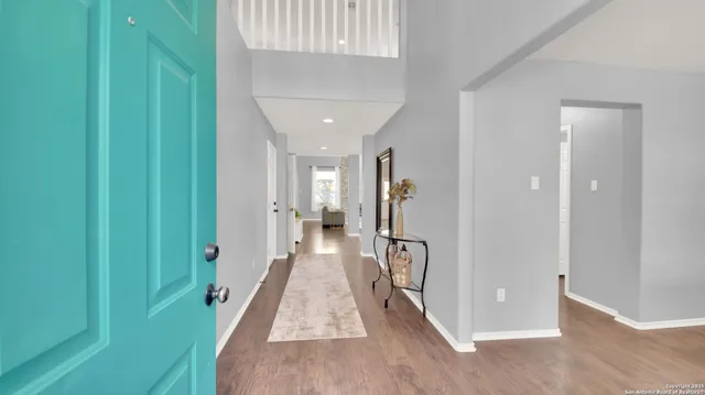 a view of a hallway with wooden floor and staircase