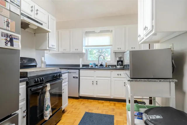 a kitchen with granite countertop a sink stainless steel appliances and cabinets