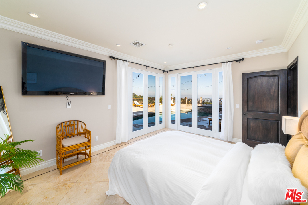 1236 Stradella Road Los Angeles, CA 90077 - Photo 12 of 26 a bedroom with a bed and a flat screen tv