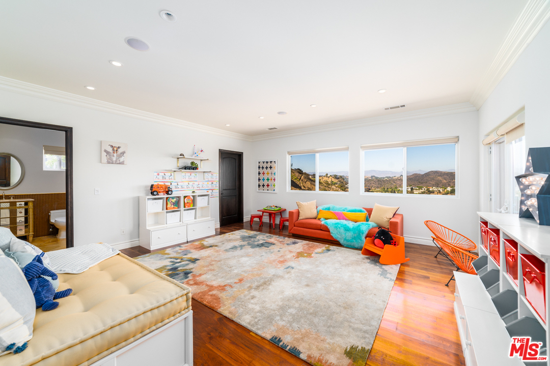 1236 Stradella Road Los Angeles, CA 90077 - Photo 15 of 26 a bed room with furniture and flat screen tv