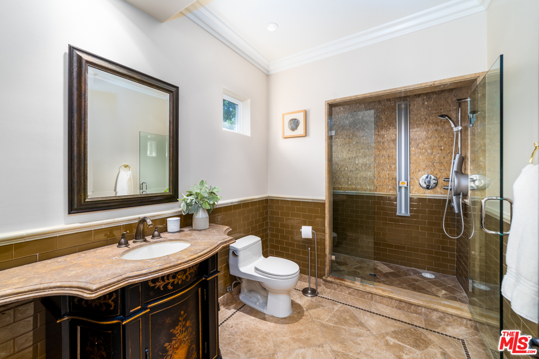 1236 Stradella Road Los Angeles, CA 90077 - Photo 22 of 26 a bathroom with a granite countertop sink a toilet a mirror and shower