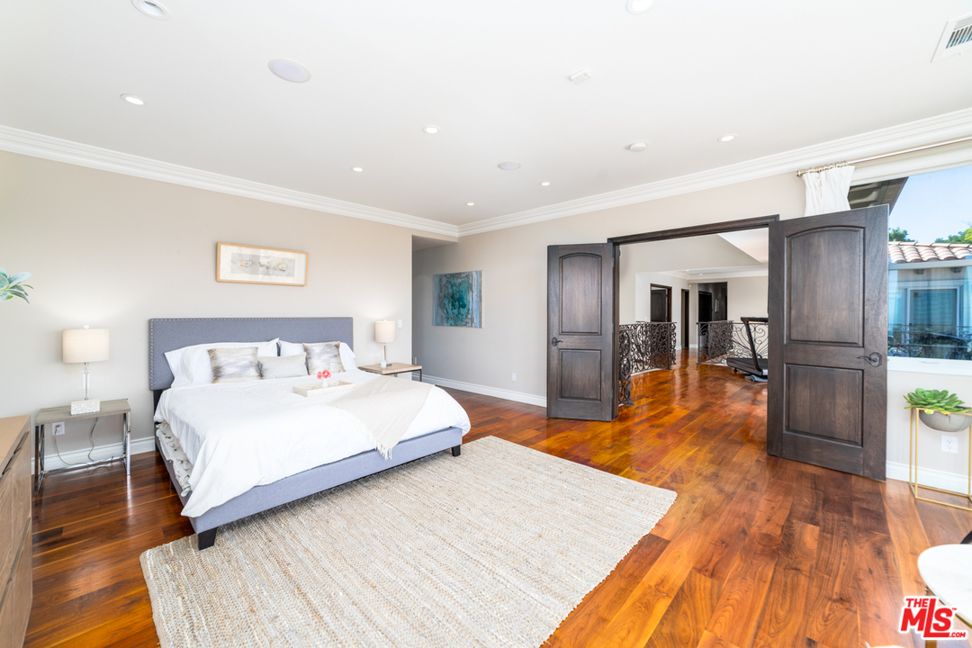 1236 Stradella Road Los Angeles, CA 90077 - Photo 24 of 26 a bedroom with a bed and a wooden floor