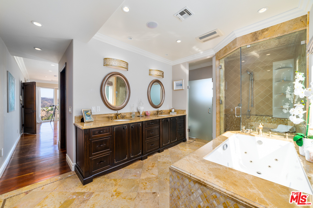 1236 Stradella Road Los Angeles, CA 90077 - Photo 25 of 26 a spacious bathroom with a granite countertop double vanity sink and a mirror