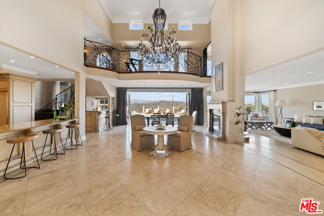 1236 Stradella Road Los Angeles, CA 90077 - Photo 4 of 26 a view of a dining room with furniture a chandelier and fireplace