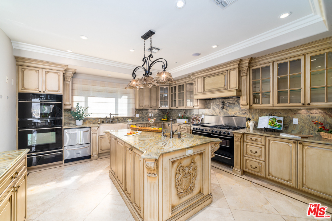 1236 Stradella Road Los Angeles, CA 90077 - Photo 6 of 26 a kitchen with stainless steel appliances granite countertop a stove top oven a sink a counter space and cabinets