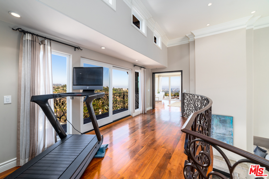 1236 Stradella Road Los Angeles, CA 90077 - Photo 9 of 26 a hallway with wooden floor a dining table and stainless steel appliances