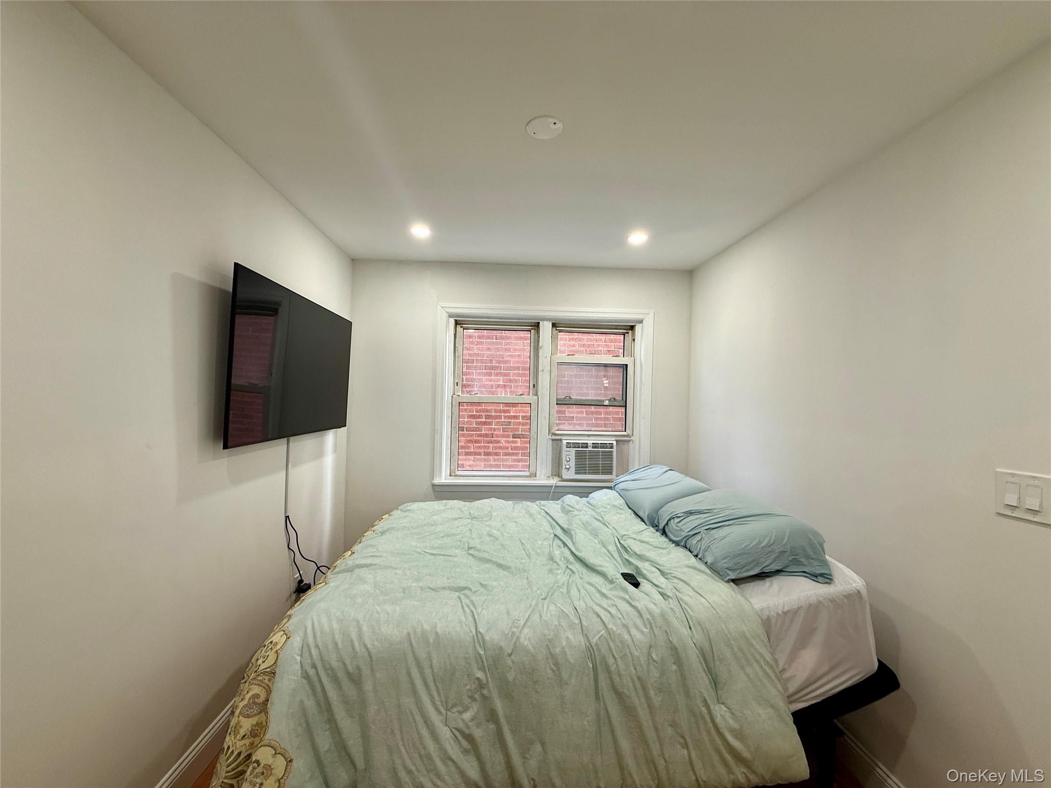 765 Shore Road, Unit 1N Long Beach, NY 11561 - Photo 11 of 13 a bedroom with a bed and a flat screen tv