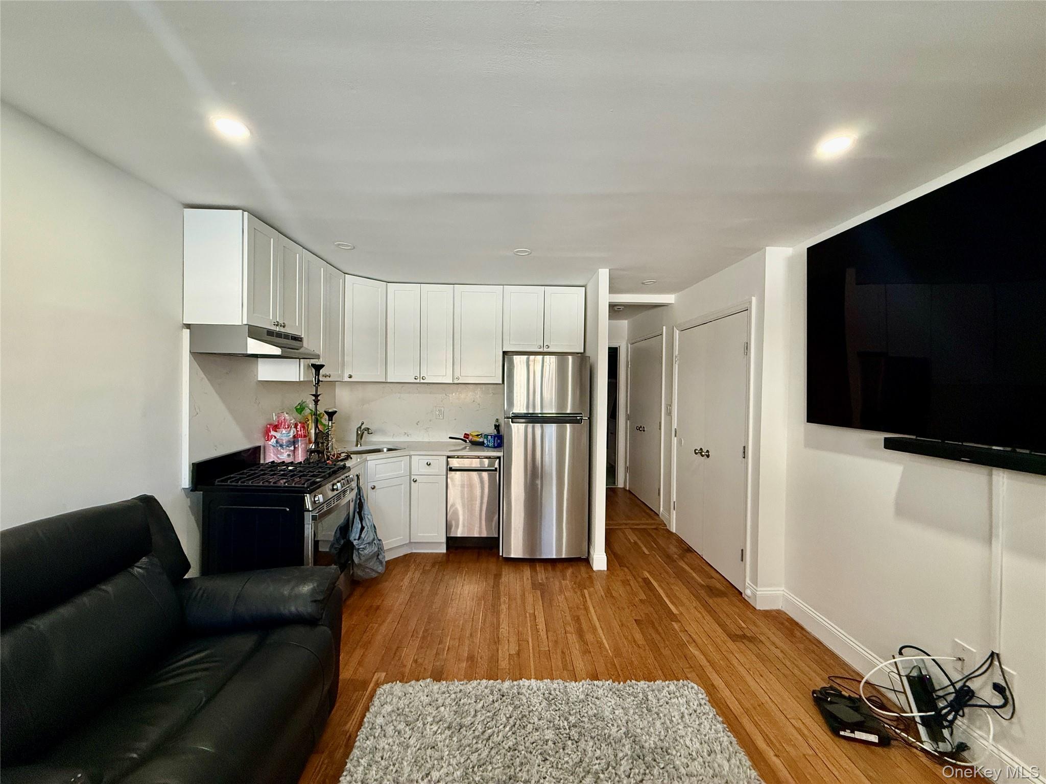 765 Shore Road, Unit 1N Long Beach, NY 11561 - Photo 3 of 13 a living room with stainless steel appliances furniture and a flat screen tv