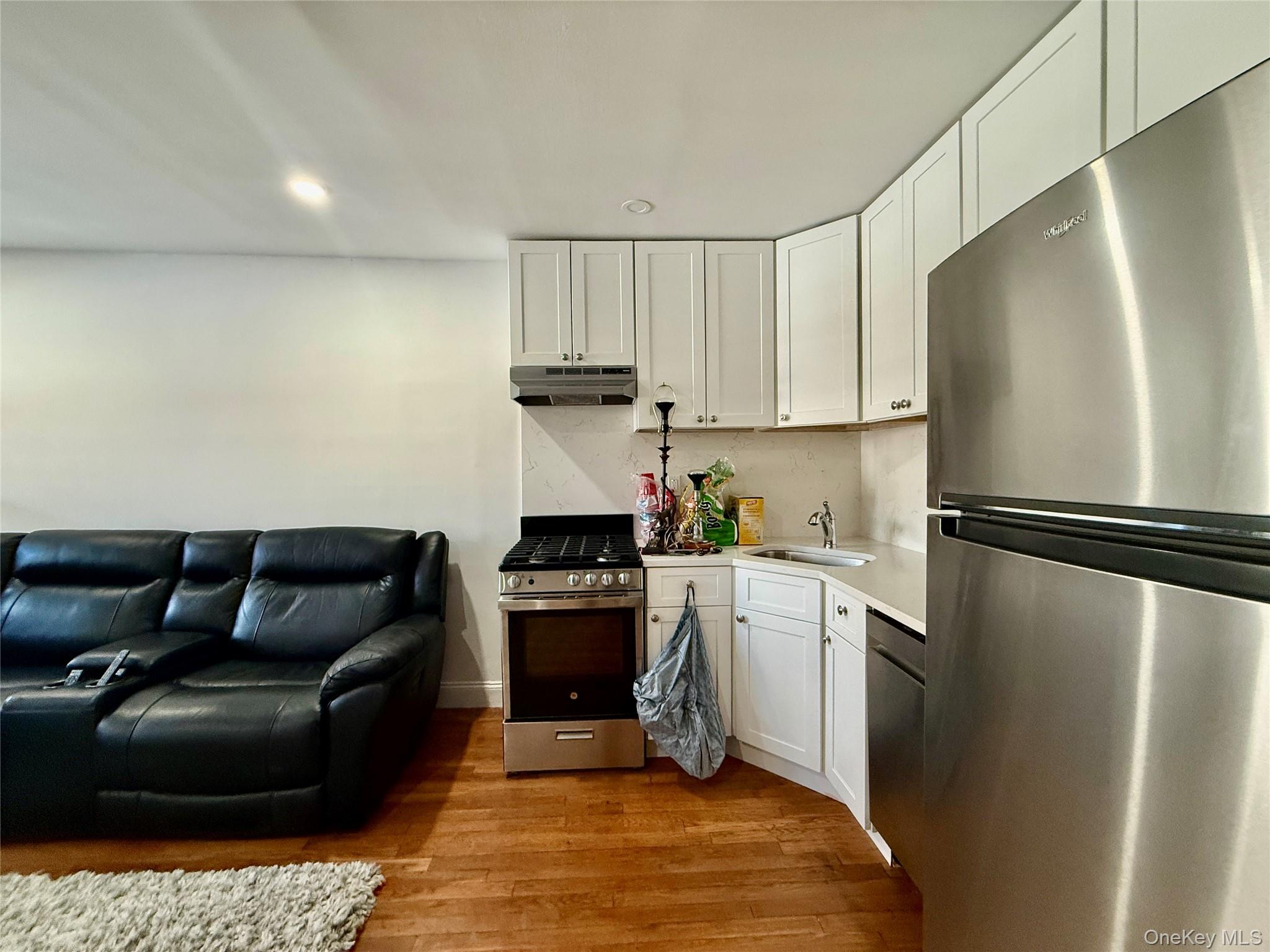 765 Shore Road, Unit 1N Long Beach, NY 11561 - Photo 5 of 13 a kitchen with a refrigerator and a stove top oven