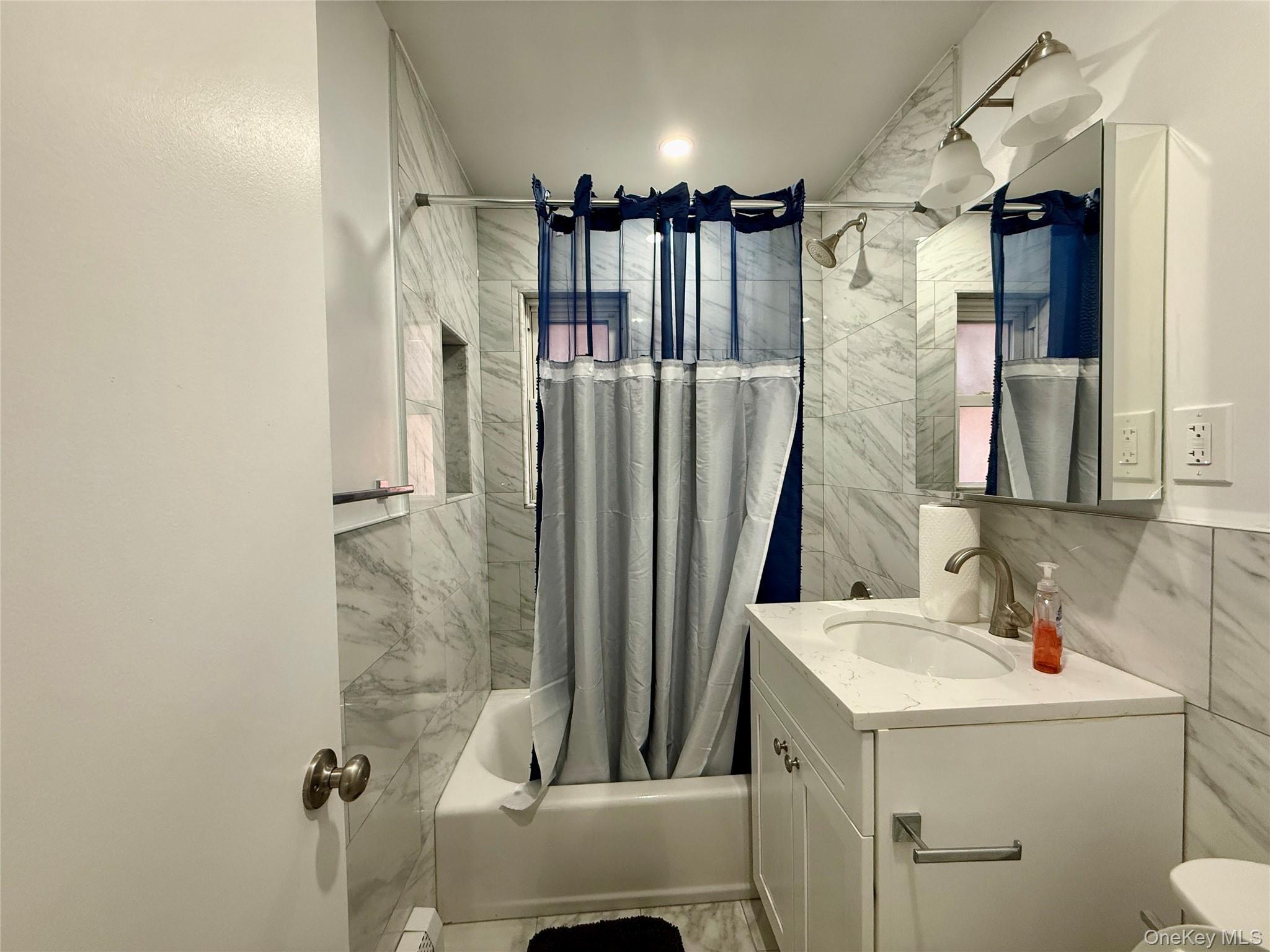 765 Shore Road, Unit 1N Long Beach, NY 11561 - Photo 7 of 13 a bathroom with a sink a toilet and shower