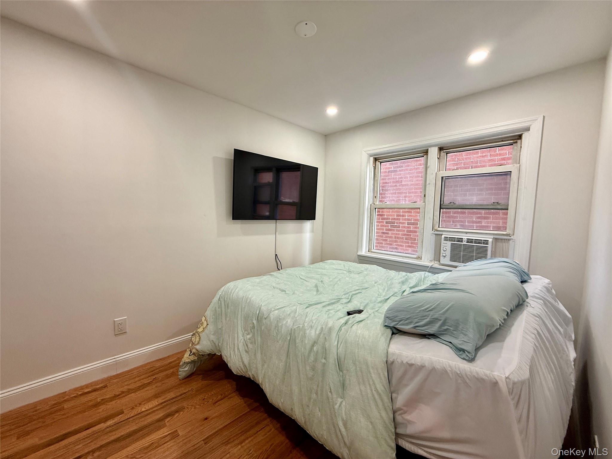 765 Shore Road, Unit 1N Long Beach, NY 11561 - Photo 9 of 13 a bedroom with a bed and a flat screen tv