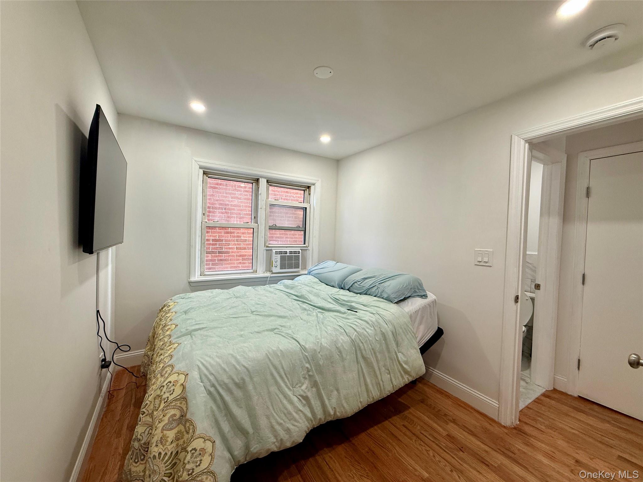 765 Shore Road, Unit 1N Long Beach, NY 11561 - Photo 10 of 13 a bedroom with a bed and a flat screen tv