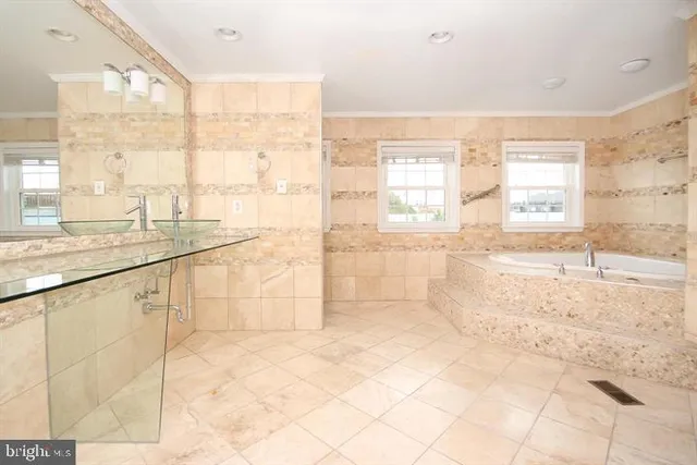 a bathroom with a granite countertop sink a large mirror and a bathtub