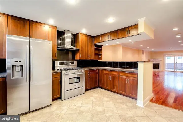 a kitchen with stainless steel appliances granite countertop a refrigerator a sink and a stove