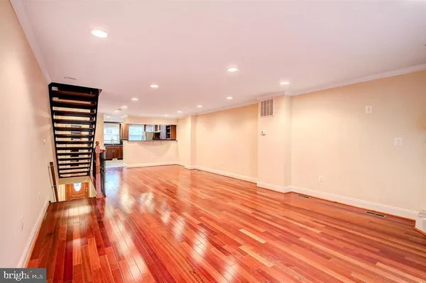 a view of empty room with wooden floor and windows