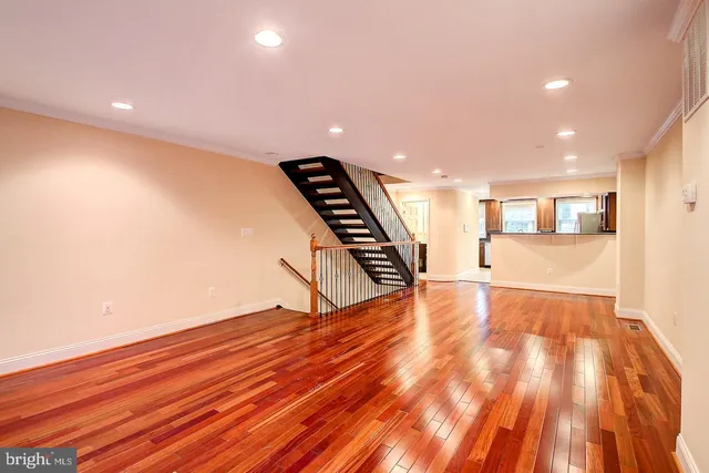 a view of an empty room with wooden floor