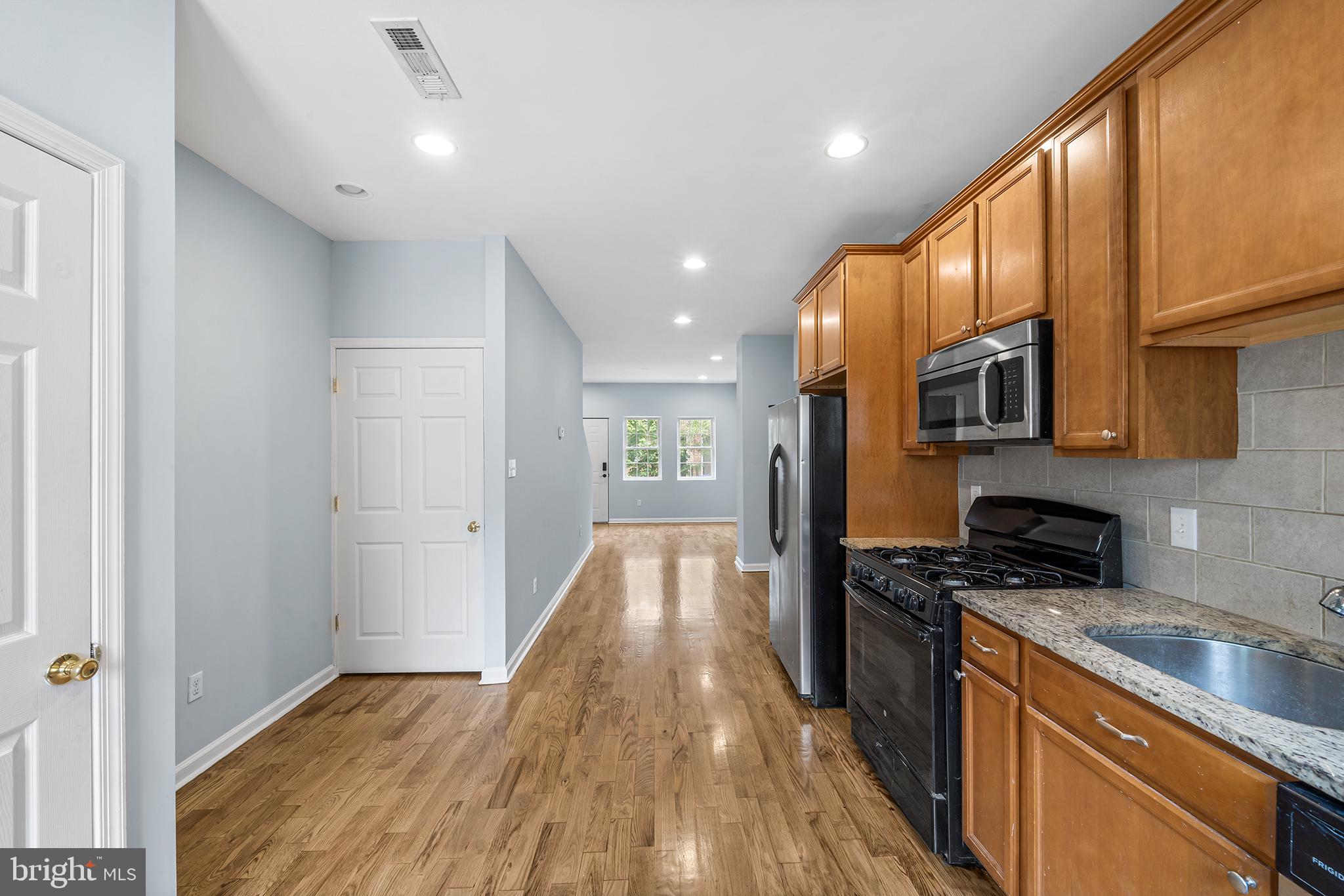 1904 Manton Street Philadelphia, PA 19146 - Photo 9 of 31 a kitchen with granite countertop a stove top oven a sink dishwasher a refrigerator and cabinets with wooden floor