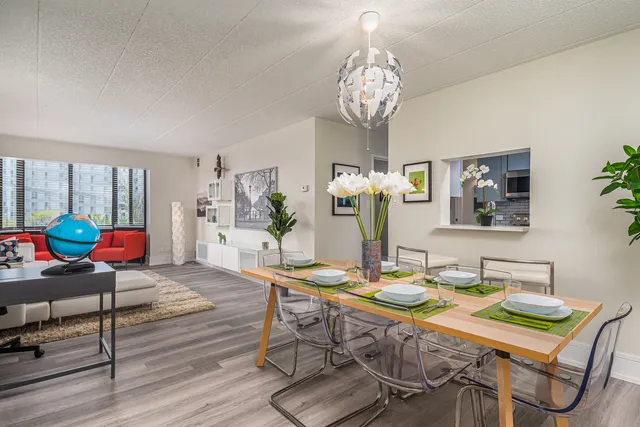 a view of a dining room with furniture a chandelier and wooden floor