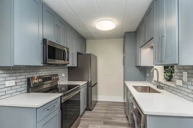 a kitchen with a sink a stove top oven and refrigerator