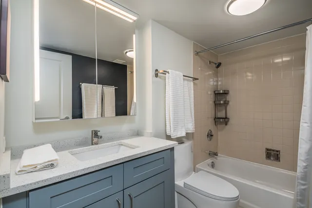 a bathroom with a granite countertop sink toilet a shower and a mirror