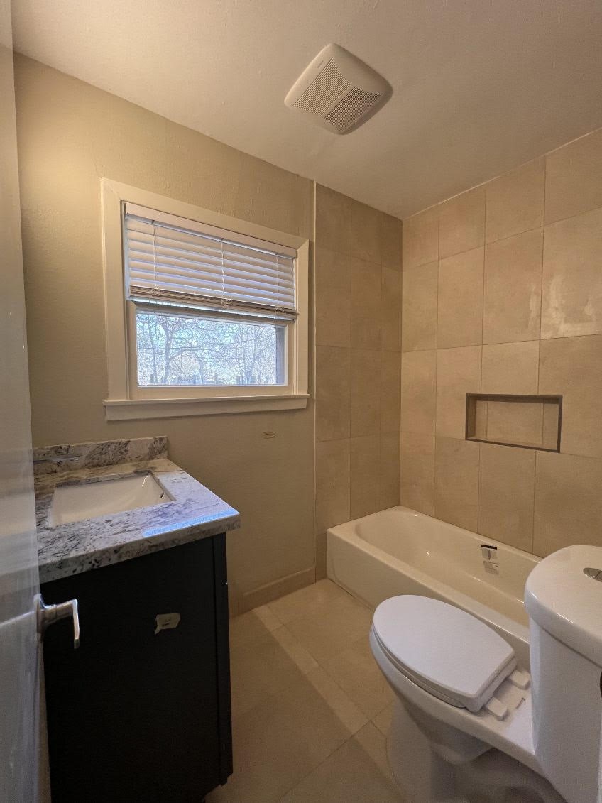 5834 Indigo Street Houston, TX 77074 - Photo 14 of 15 a bathroom with a granite countertop toilet sink and mirror