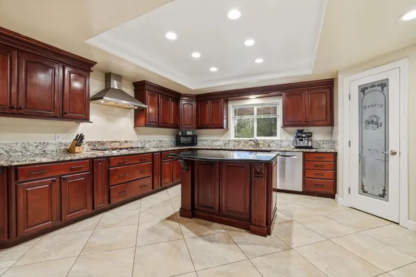 a kitchen with stainless steel appliances granite countertop a refrigerator and a stove top oven