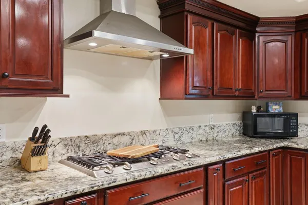 a kitchen with stainless steel appliances granite countertop wooden cabinets a stove top oven a sink and dishwasher