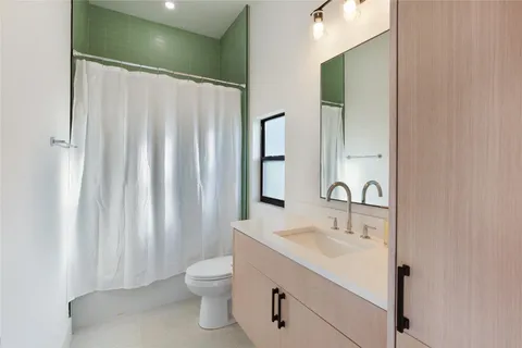 a bathroom with a sink a toilet and shower curtain