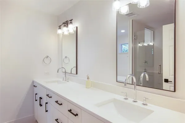 a bathroom with double vanity sinks and a mirror