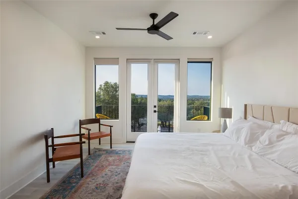 a large bedroom with a bed and large windows