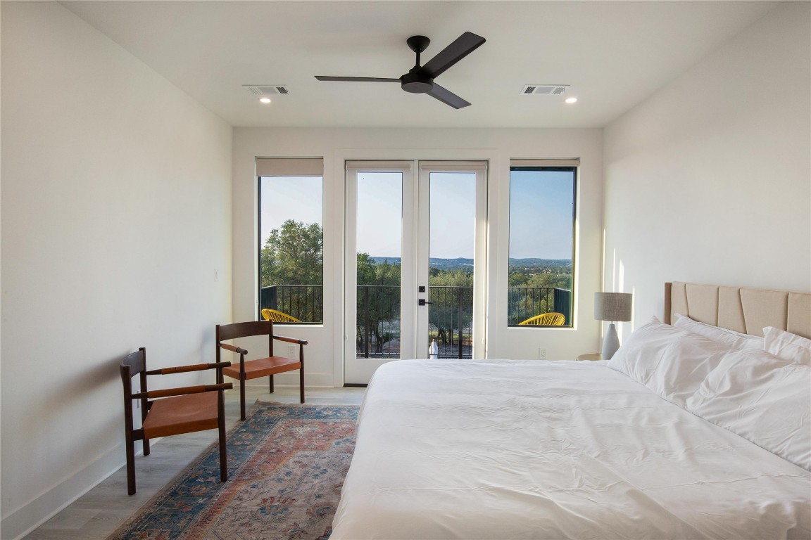171 Hart Lane Dripping Springs, TX 78620 - Photo 28 of 40 a large bedroom with a bed and large windows