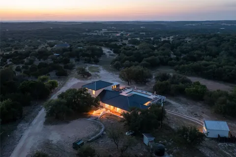 an aerial view of house with yard and mountain view in back