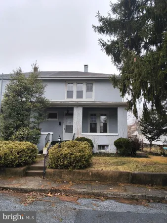 a front view of a house with garage and plants