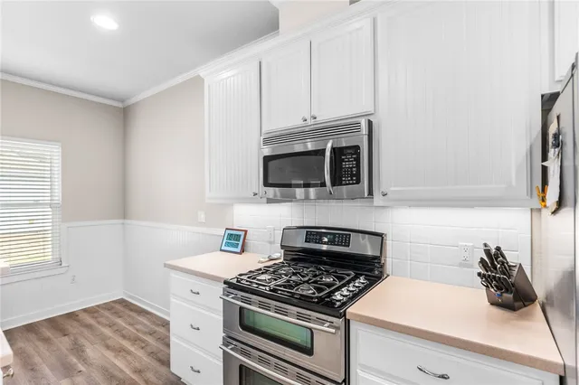 a kitchen with stainless steel appliances a stove a microwave and cabinets