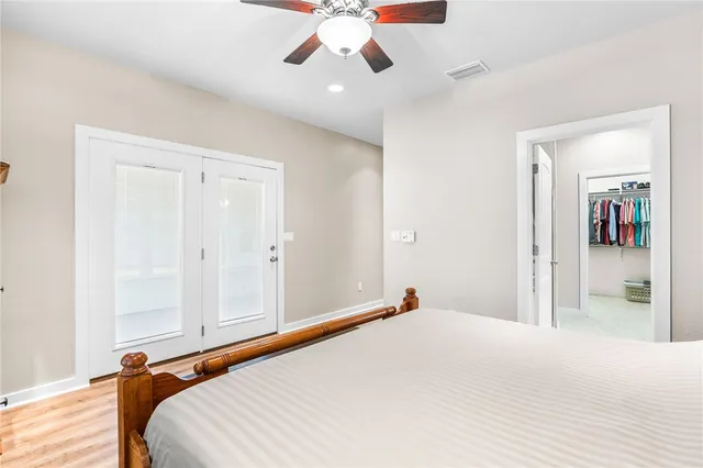 a bedroom with a large bed and a chandelier fan