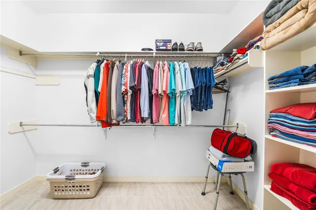 a view of walk in closet with clothes and shoes