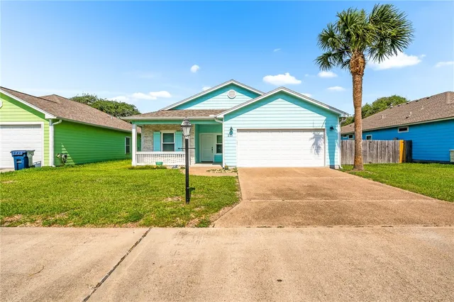 a front view of a house with a garden and yard