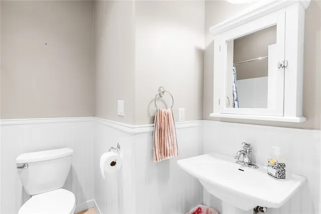 a bathroom with a sink a toilet and a mirror