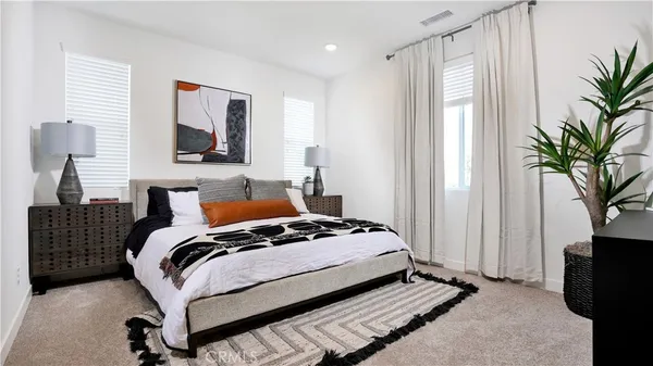 a bedroom with bed and a potted plant