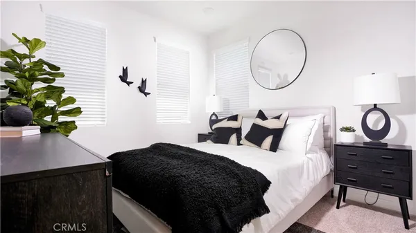 a bedroom with a bed mirror and a window