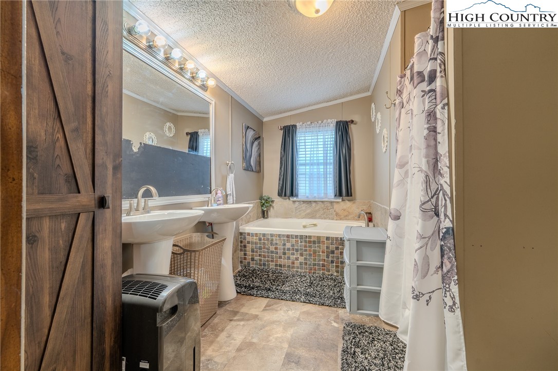 672 Upper Hanging Rock Road Spruce Pine, NC 28777 - Photo 11 of 22 a bathroom with a sink and a mirror
