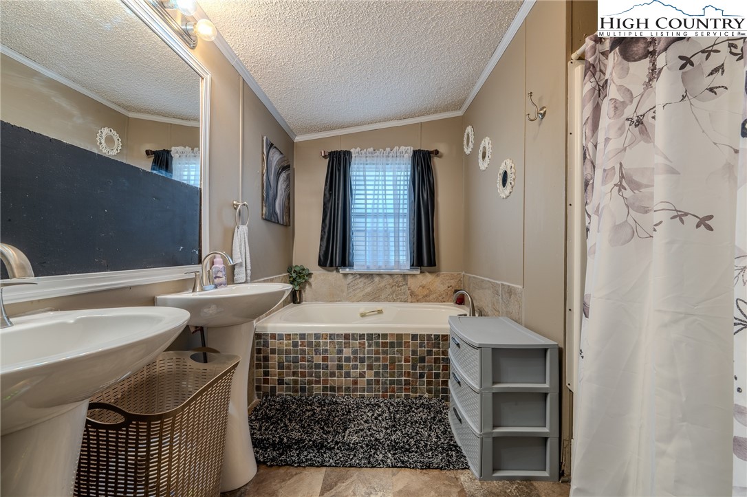 672 Upper Hanging Rock Road Spruce Pine, NC 28777 - Photo 13 of 22 a bathroom with a sink and a bathtub